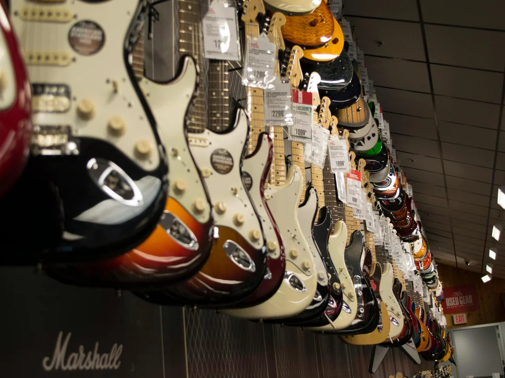 plusieurs guitares électriques à 6 et 12 cordes sont alignées les unes derrières les autres de différentes couleurs